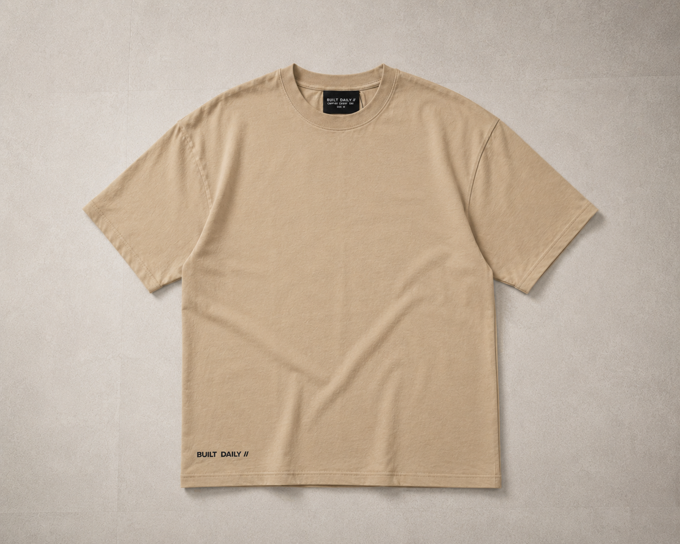Sand oversized Built Daily top with minimal chest branding.